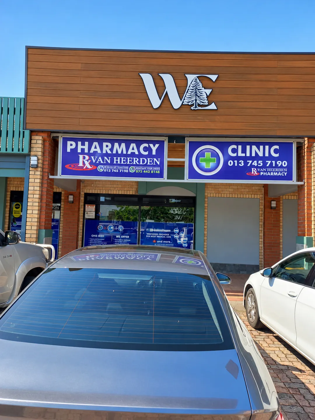 A pharmacy and clinic entrance with parking in front